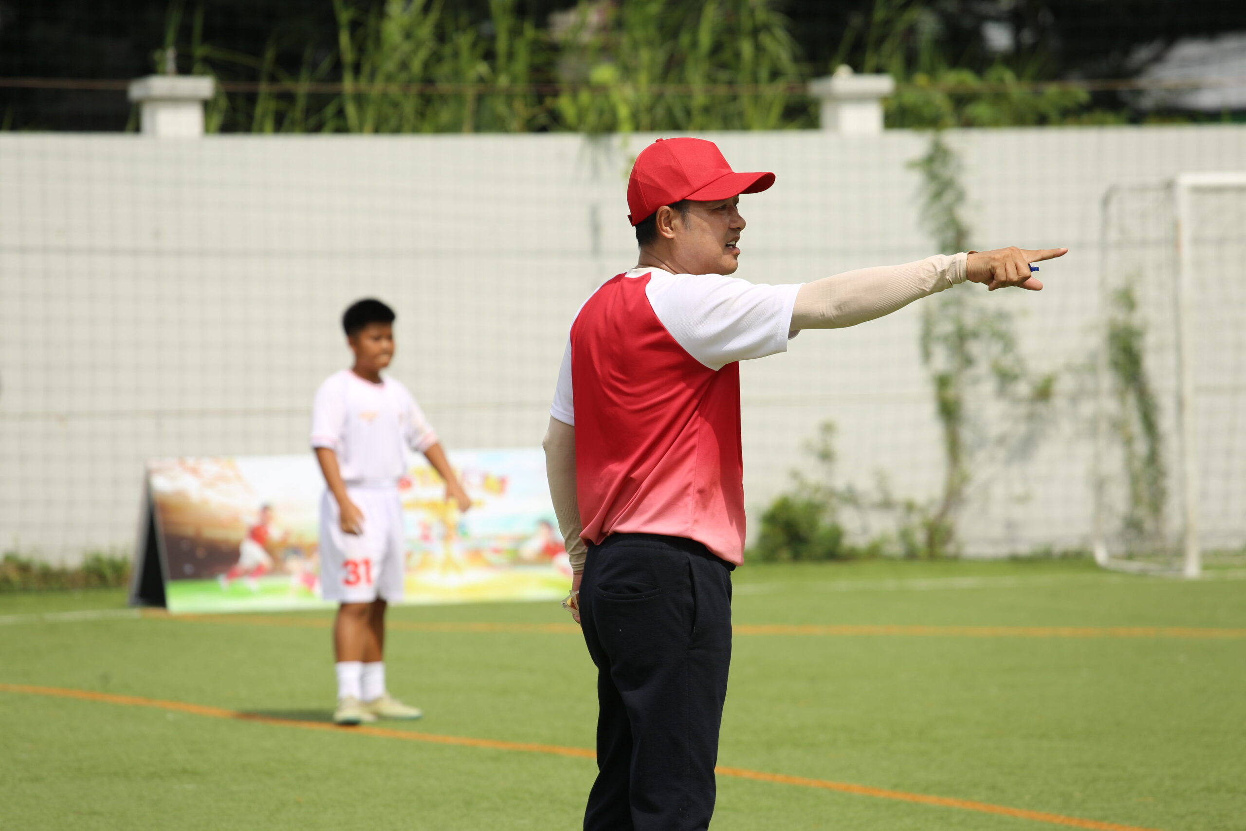 HLV Hồng Sơn đốc thúc tinh thần các cầu thủ nhí trong giai đoạn cuối của chặng 2.